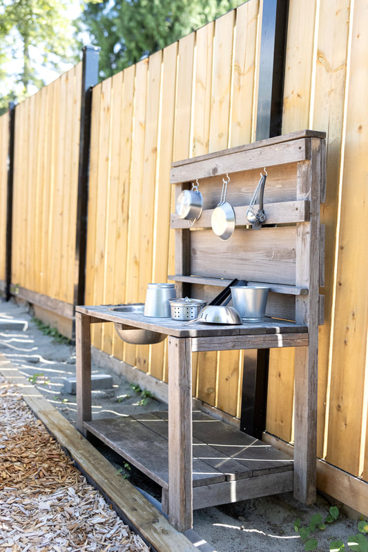 Mud kitchen with stainless pots